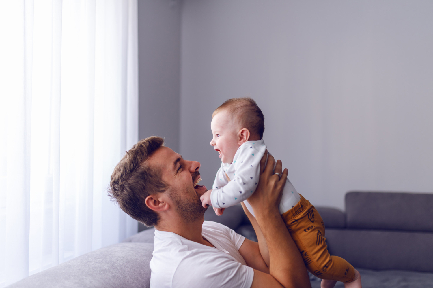 Image of a father playing with her baby